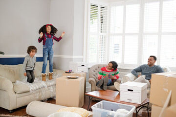 Obraz premium Family taking a break from moving, relaxing in living room