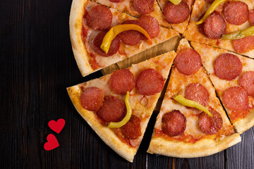 Pepperoni pizza and heart symbol on wood background. Pizza love concept