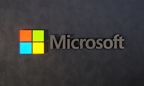 Three-dimensional logo of American technology corporation Microsoft against dark wall. Editorial 3D illustration