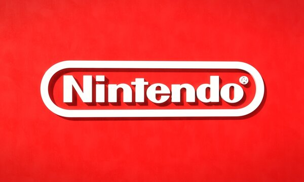 Three-dimensional logo of Japanese consumer electronics and video game company Nintendo against red backdrop. Editorial 3D illustration