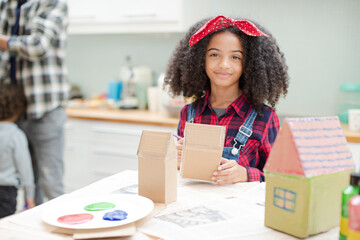 Girl painting cardboard houses