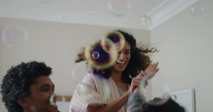 happy family playing with soap bubbles at home cute little boy having fun with mother and father enjoying playful game on weekend morning 4k