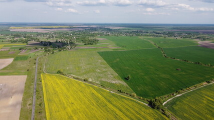 Fototapeta na wymiar Colorful farm fields around a small village, aerial view.