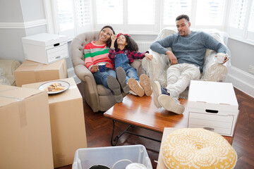 Family taking a break from moving, relaxing in living room