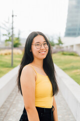 portrait of young asian friendly woman posing outdoor smiling