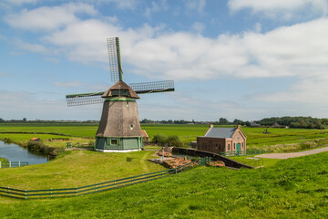 Old windmill in Schellinkhout in West Friesland, Netherlands. The polder mill was built between 1603 and 1638. - obrazy, fototapety, plakaty