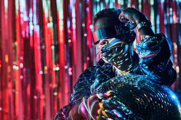 Cool black model in futuristic glasses with glitter ball