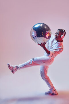 Trendy black model in headphones with disco ball