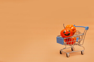 Orange pumpkins in a cart and scattered pumpkins on a beige background. flat lei on the topic of...