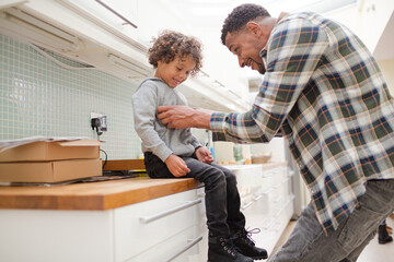 Father putting shoes on son