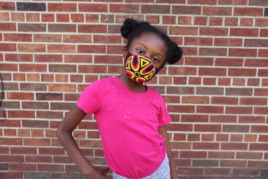 Cute Kid wearing colorful face mask brick wall background - Powered by Adobe