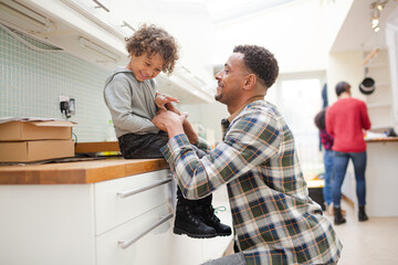 Father putting shoes on son