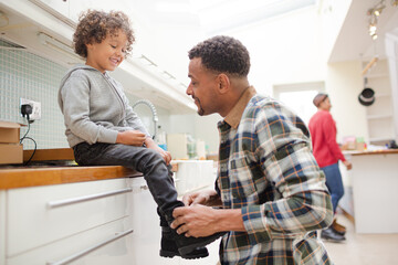 Fototapeta premium Father putting shoes on son