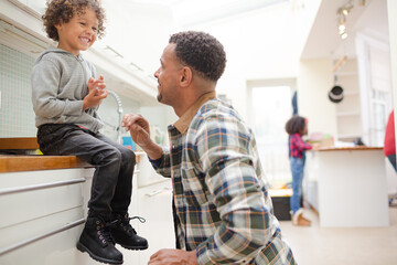 Obraz premium Father putting shoes on son