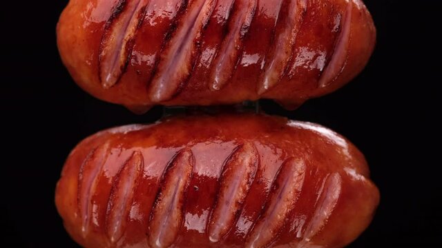 Fried sausages close up on black background.  4K UHD video 