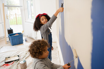 Happy children painting wall
