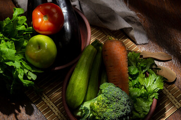 vegetables and fruits in wooden bowl with light from a window playing with the lights and shadows