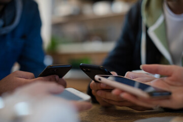 Young adults using smart phones at table