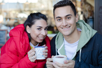 Teenage couple holding cups
