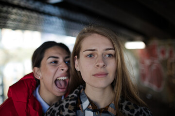 Angry young woman yelling at friend