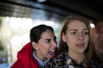 Fototapeta na wymiar Angry young woman yelling at friend
