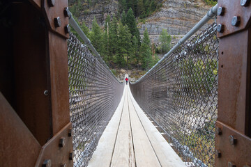 Man walking on a swinging bridge