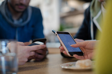 Young adults using smart phones at table