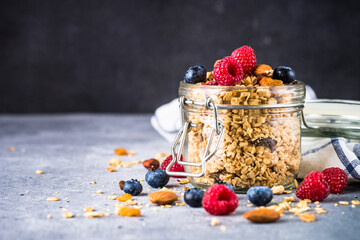 Granola with fresh berries in the glass jar. Healthy dessert or snack.