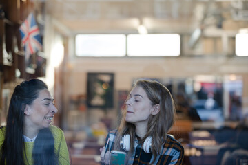 Young female college students studying at cafe window