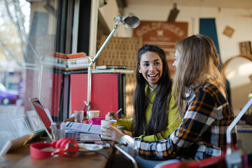 Young female college students studying in cafe