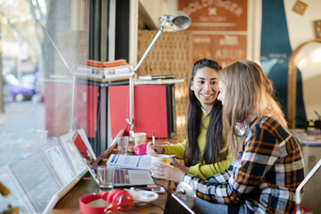 Young female college students studying in cafe