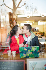 Young couple using smart phone and laptop in cafe