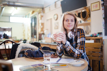 Portrait confident young female college student studying at cafe table