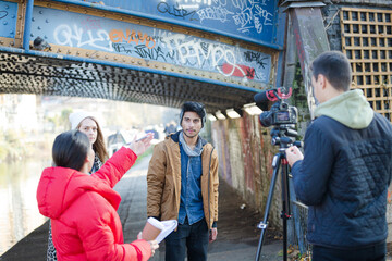 Fototapeta premium Young adults vlogging under urban bridge