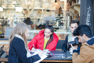 Young adult friends talking at sidewalk cafe