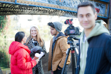 Young adults vlogging under urban bridge