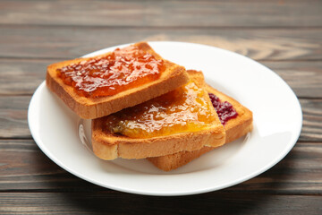 Fresh toast with butter and different jams on table