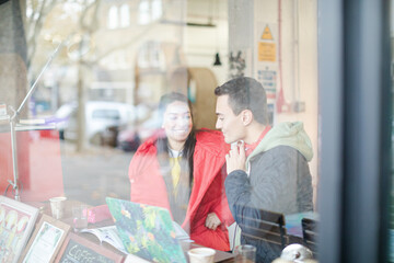 Young couple studying at cafe window