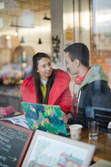 Young couple studying at cafe window