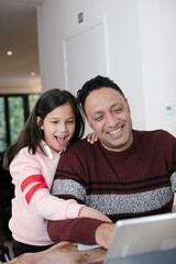 Father and daughter using digital tablet in kitchen