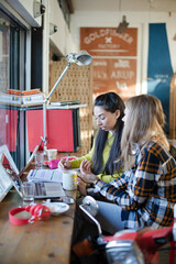 Young female college students studying in cafe