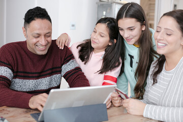 Family using digital tablet at kitchen table