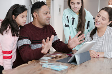 Family using digital tablet at kitchen table