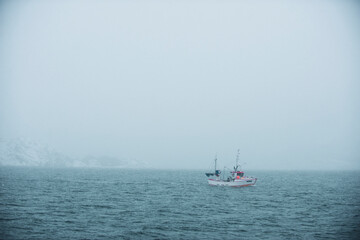 fishing boat in foggy ocean in northern norway