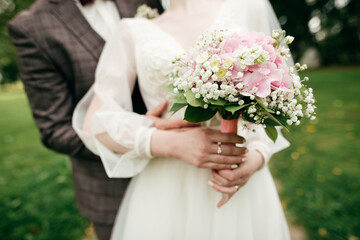 Obraz na płótnie Canvas Bride holding her bouquet with pink hydrangea