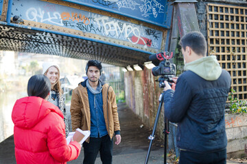 Young adults vlogging under urban bridge