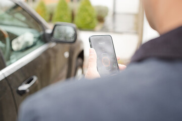 Personal perspective man setting car alarm from smart phone