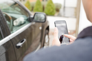 Personal perspective man setting car alarm from smart phone