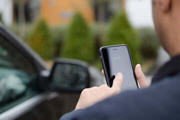 Personal perspective man setting car alarm from smart phone