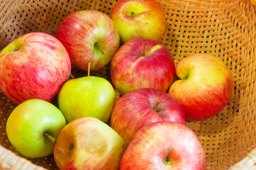 red apples in a wicker plate close-up, fresh harvest